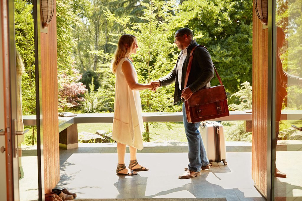 An Airbnb host (left) greeting a guest. The company plans to introduce its first loyalty program in a few months.
