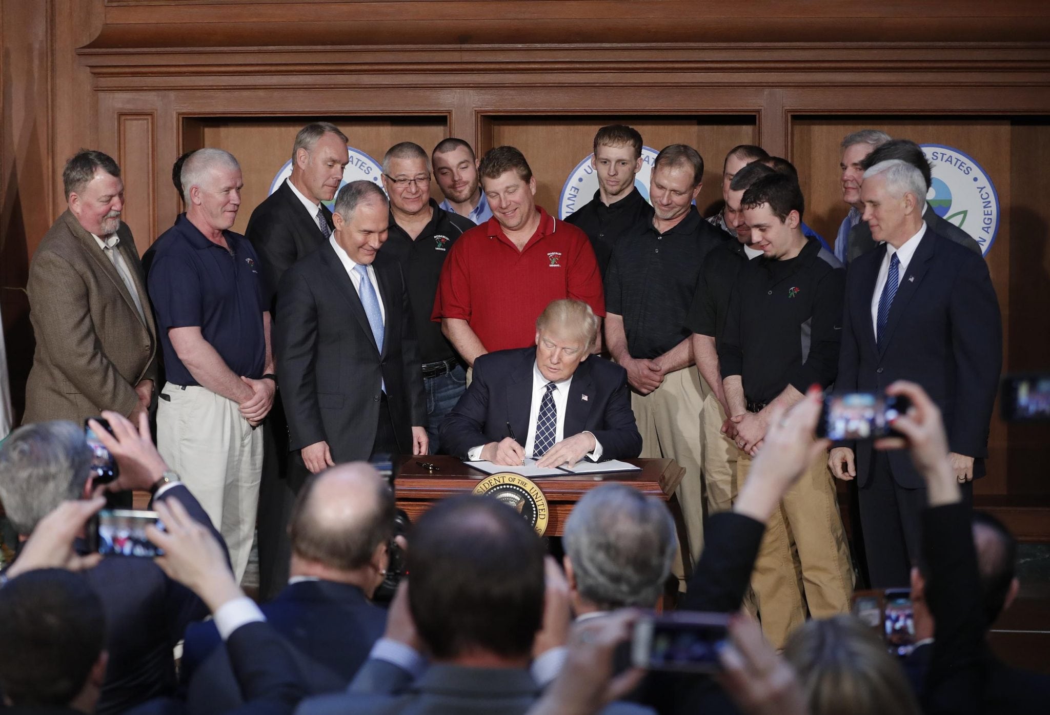 President Donald Trump, accompanied by Environmental Protection Agency (EPA) Administrator Scott Pruitt, third from left, and Vice President Mike Pence, right, signs an Energy Independence Executive Order, Tuesday, March 28, 2017, at EPA headquarters in Washington.