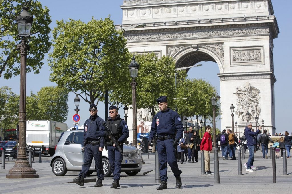 French riot police officers patrol on the Champs Elysees boulevard, with the Arc of Triomphe in background, in Paris, Friday, April 21, 2017. 