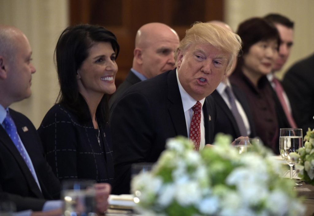 Trump's road to the White House, paved in big, sometimes impossible pledges, has detoured onto a byway of promises deferred or left behind, an Associated Press analysis found. He's pictured with UN ambassador Nikki Haley.