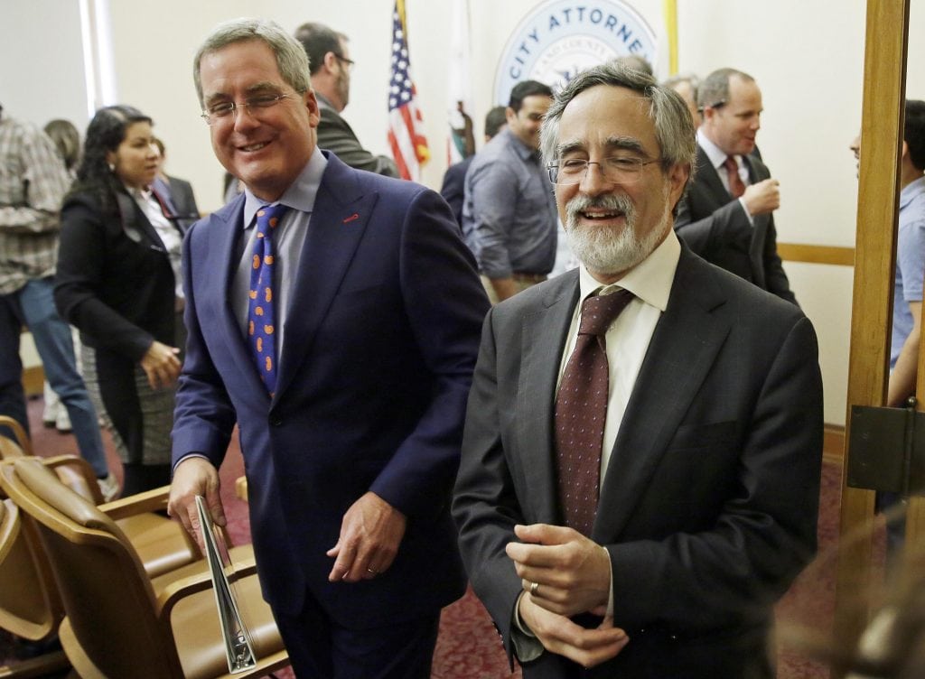 City Attorney Dennis Herrera, left, smiles while walking with San Francisco Supervisor Aaron Peskin, right, after announcing a settlement agreement on short term rentals during a news conference Monday, May 1, 2017, at City Hall in San Francisco. 