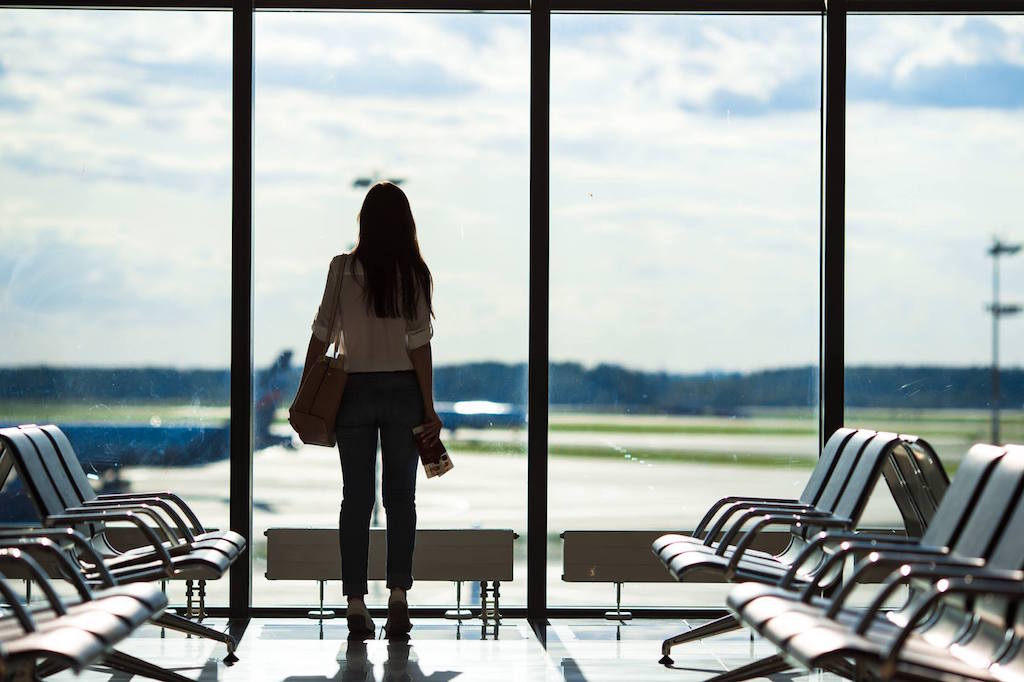 Are travel managers and corporations missing out by downplaying employee feedback? Pictured is a woman at an airport.