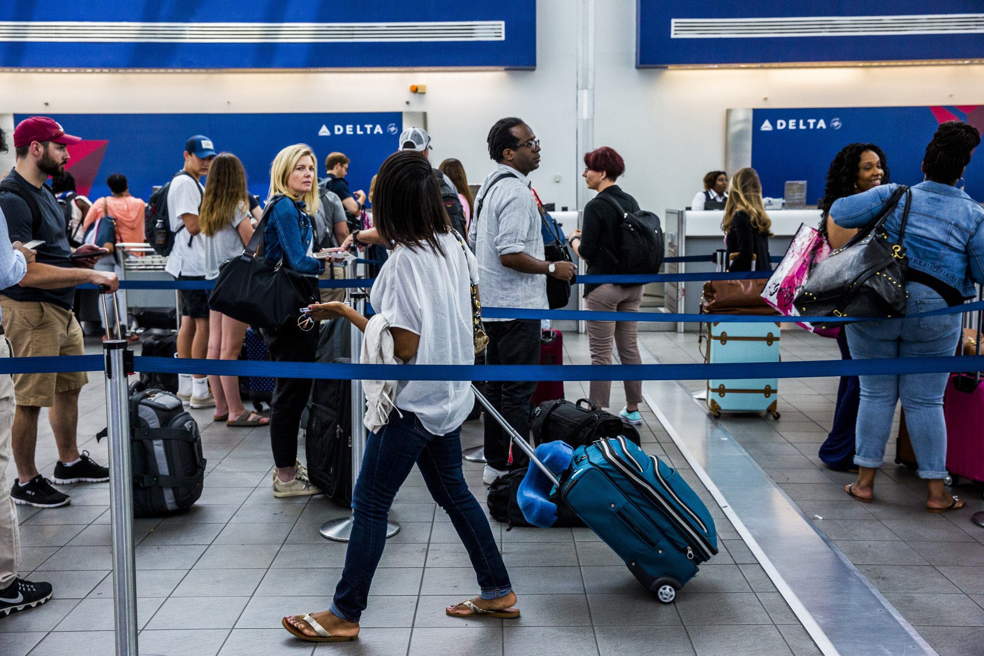 Pictured are travelers and their luggage at an airport. American Airlines just launched enhanced baggage tracking.