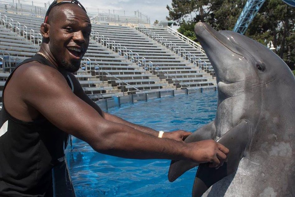 UFC Light Heavyweight Champion Jon Jones poses with "Sandy," a bottlenose Dolphin, at SeaWorld San Diego August 2, 2017. ASTA's global conference was to host an opening reception at SeaWorld August 27, 2017.
