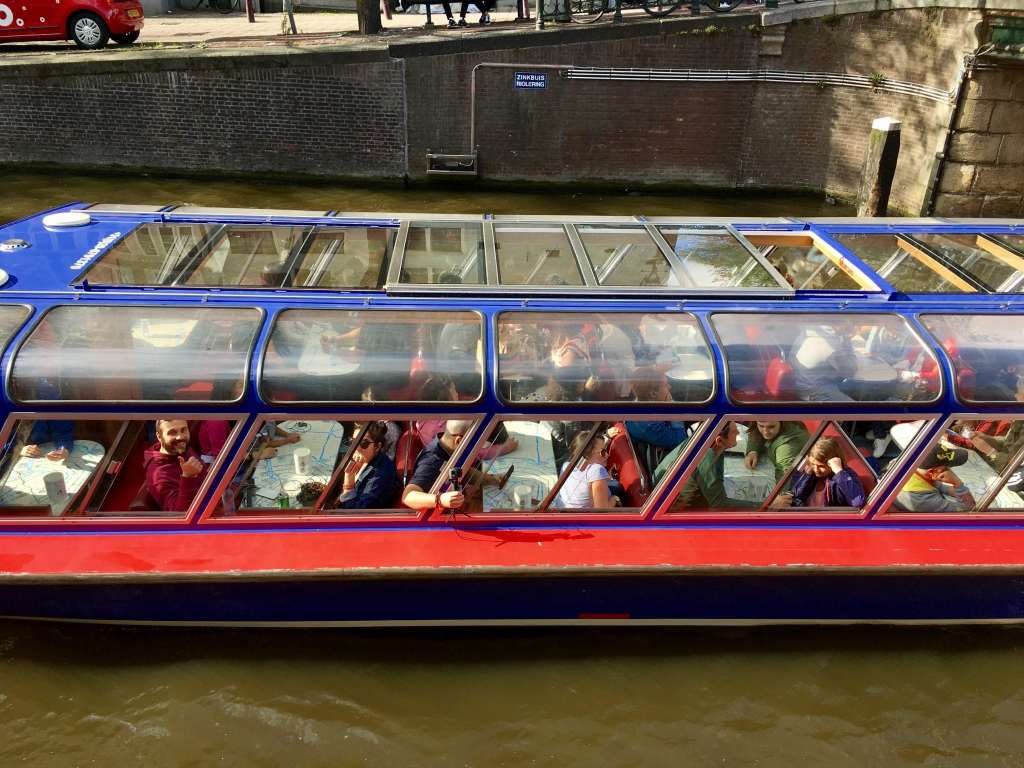 a boat filled with tourists moving along a canal