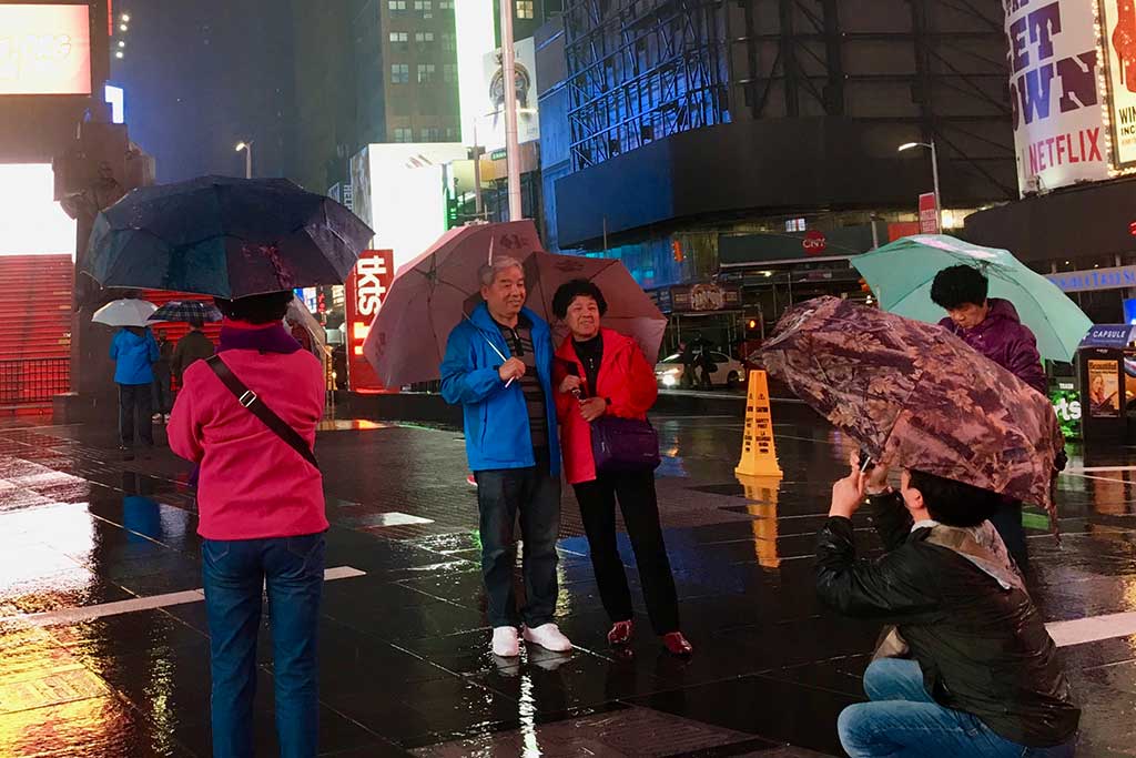 Tourists taking a photo in the rain in New York City's Times Square. 