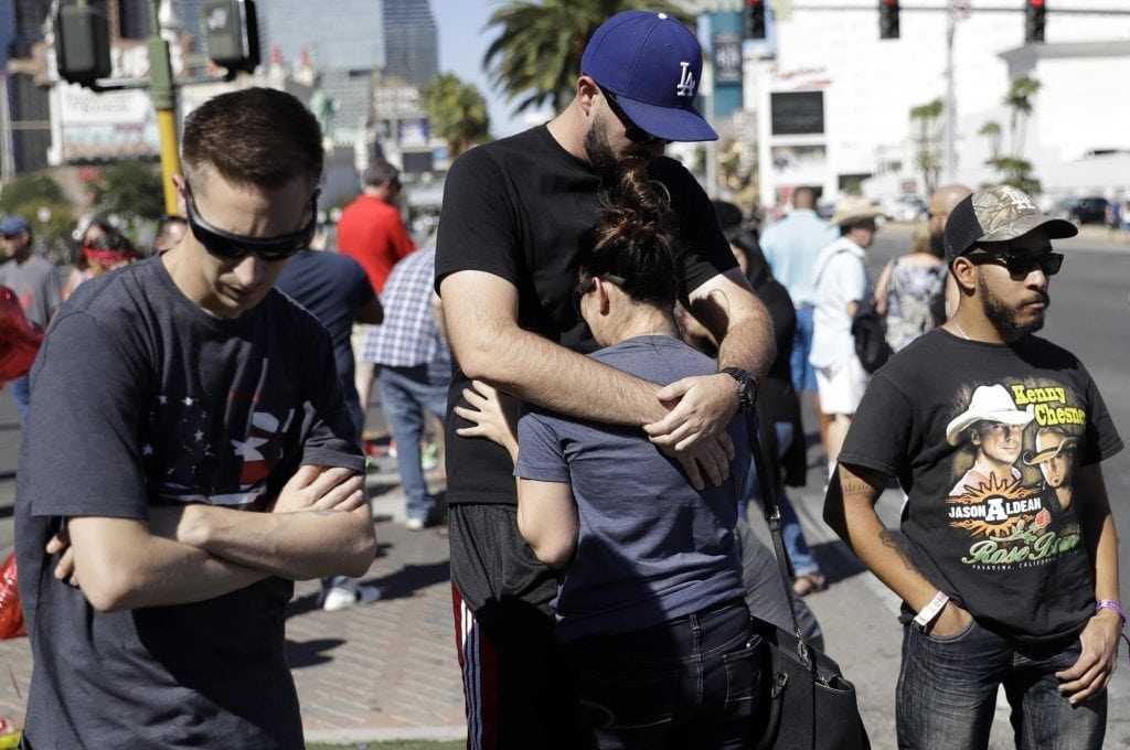 Reed Broschart, center, hugs his girlfriend Aria James on the Las Vegas Strip in the aftermath of a mass shooting at a concert Monday, Oct. 2, 2017, in Las Vegas. The couple, both from Ventura, Calif., attended the concert. 