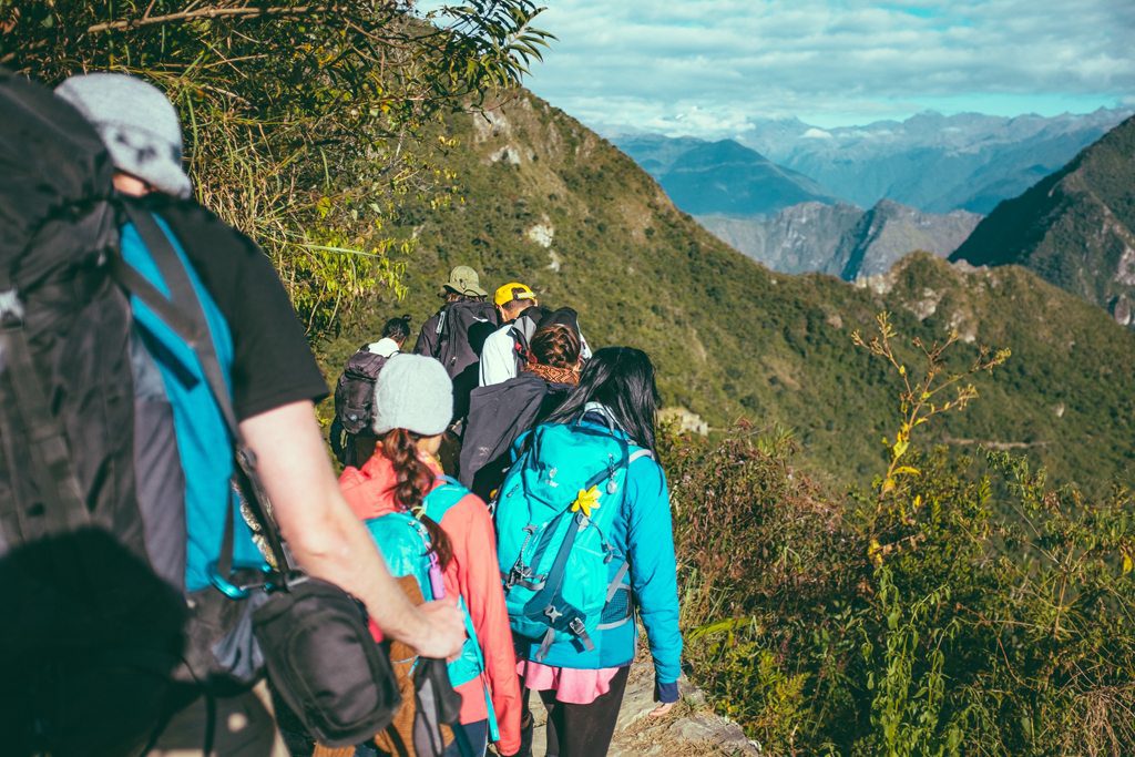 Multi-day group hikers trek Peru from Aguas Calientes to Machu Picchu.