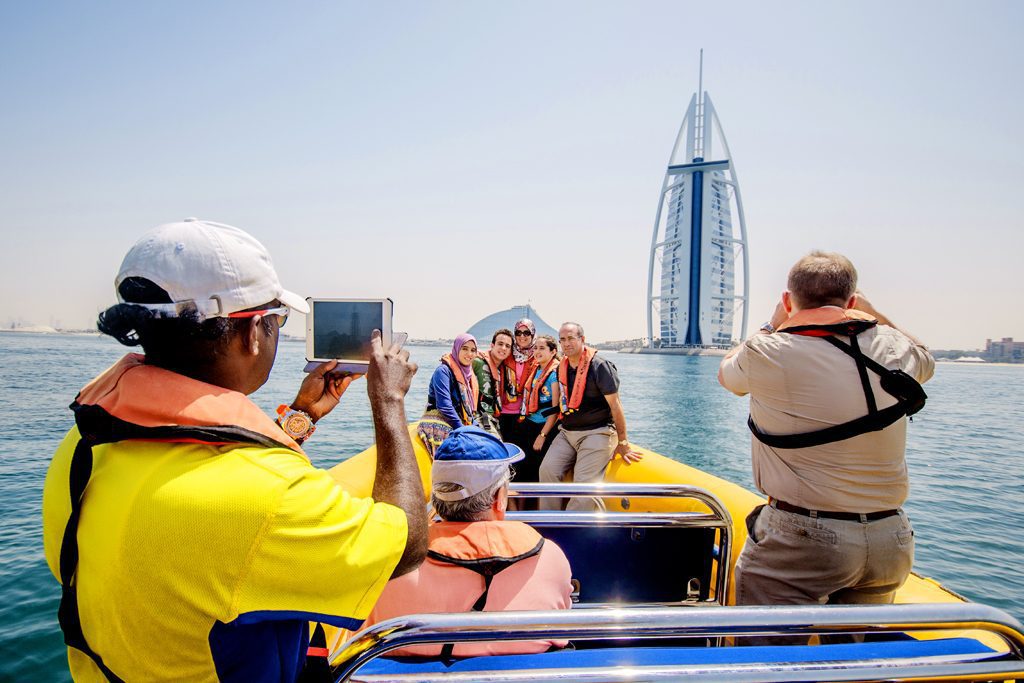 Travelers on a guided tour admire the Burj Al Arab landmark in Dubai in the United Arab Emirates. GetYourGuide, an activities retailer, wants to put its brand on tours similar to this one.
