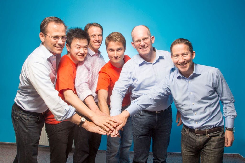 GetYourGuide's founders wearing orange shirts (Tao Tao on the left, Johannes Reck in the center) posed for a photo with some of the company's board members -- Philipp Freise, Kees Koolen, and Fritz Demopoulos -- but not its newest one from Battery Ventures. Alex Finkelstein from Spark Capital is between Tao and Reck.