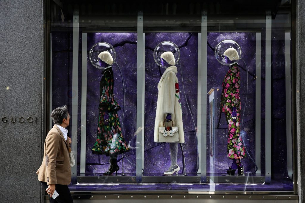 A pedestrian looks at the window display at a Gucci store in central Milan, Italy. Luxury travel can still learn a lot from luxury fashion.