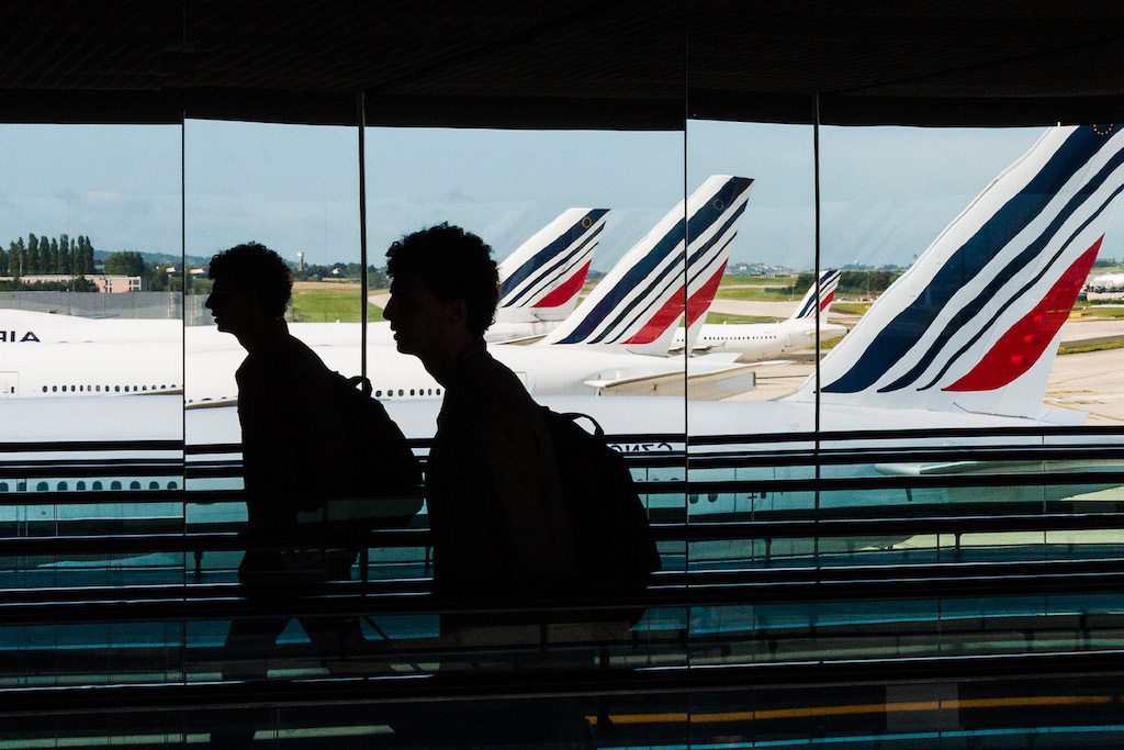 A file photo of a passenger walks down a mirrored hallway in the Charles de Gaulle airport in Paris, France. France will announce a new policy on coronavirus quarantines.