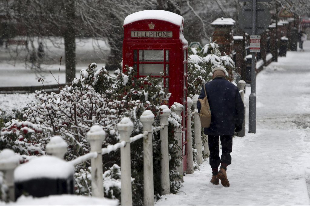 A man walks past a snow-covered phone box in Marlow, England. Wintry weather prompts people to start thinking about sunnier climes.