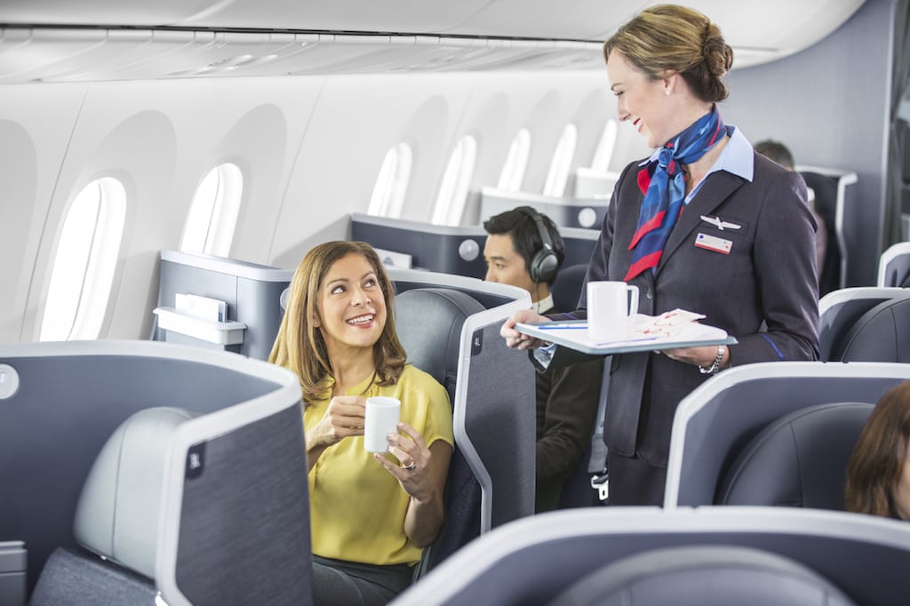 Flight attendants serve drinks to American Airlines business class passengers. Someday, American could serve its best customers what it thinks they'll want — before they ask for it. 
