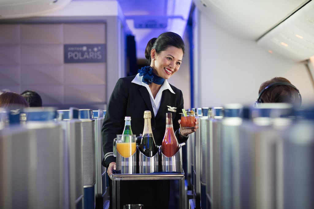 Pictured, a flight attendant in United's Polaris business class section of an aircraft. United is seeing strong demand for its Polaris business class seats from leisure travelers, although they don't generally pay as much for the lie-flat seats.