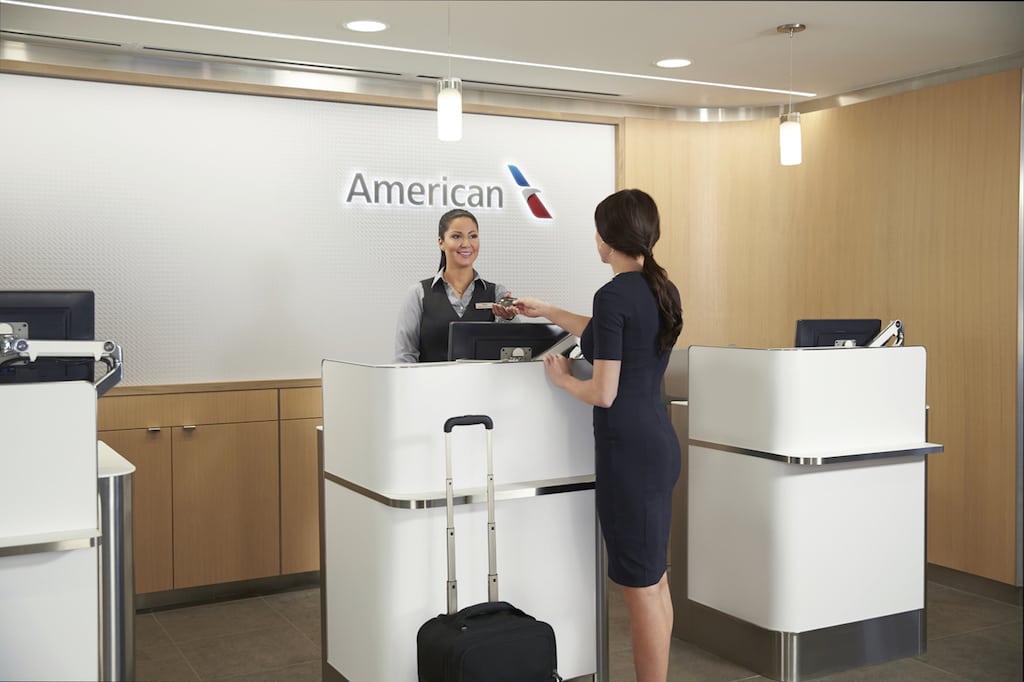 A customer speaks to an agent at an American Airlines club. American has made investments in many of its lounges. 