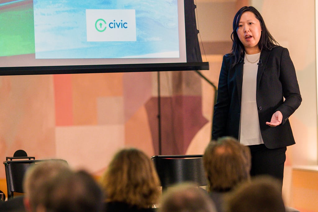 Suzanna Chiu, head of startups for travel technology company Amadeus, talks to a crowd about one of the company's corporate venture capital investments in Civic, a specialist in identity management using blockchain.