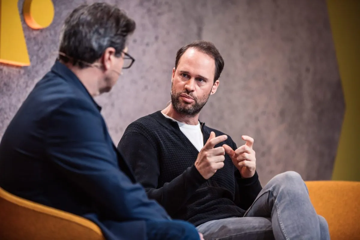 Two people in conversation on stage at a conference.