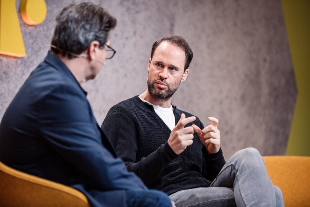 Booking.com CMO Pepijn Rijvers (center) and Skift executive editor Dennis Schaal speaking at Skift Forum Europe in Berlin Germany on April 26, 2018.