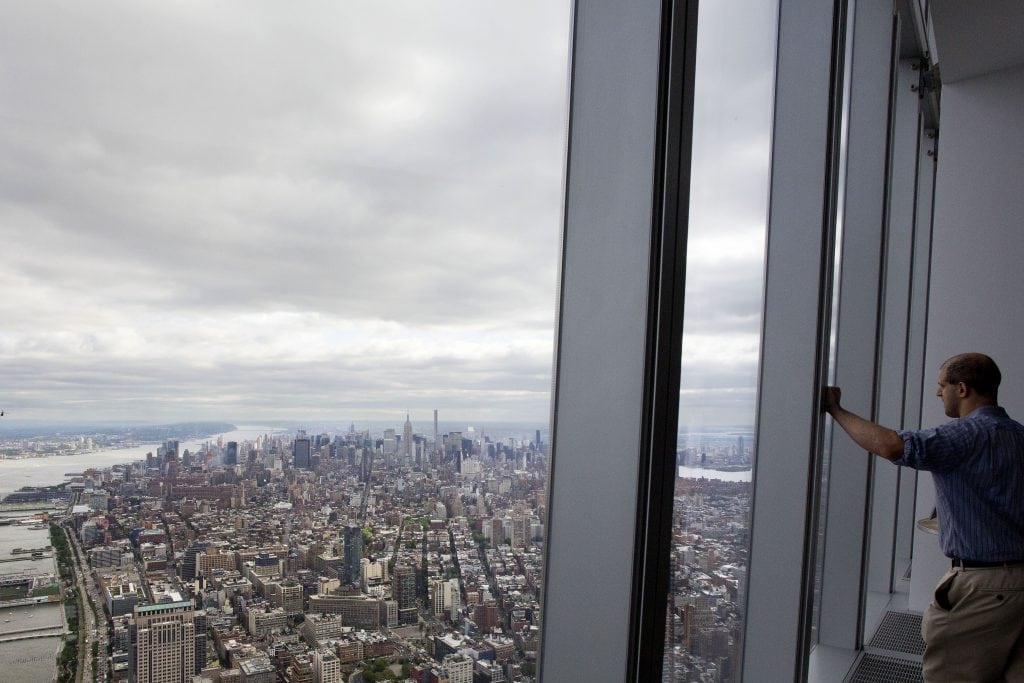 A visitor to One World Observatory looks over Manhattan, in New York. The observatory atop the 104-story One World Trade Center opened to the public on May 29, 2015. New York City has many of the most travel zip codes in the U.S.