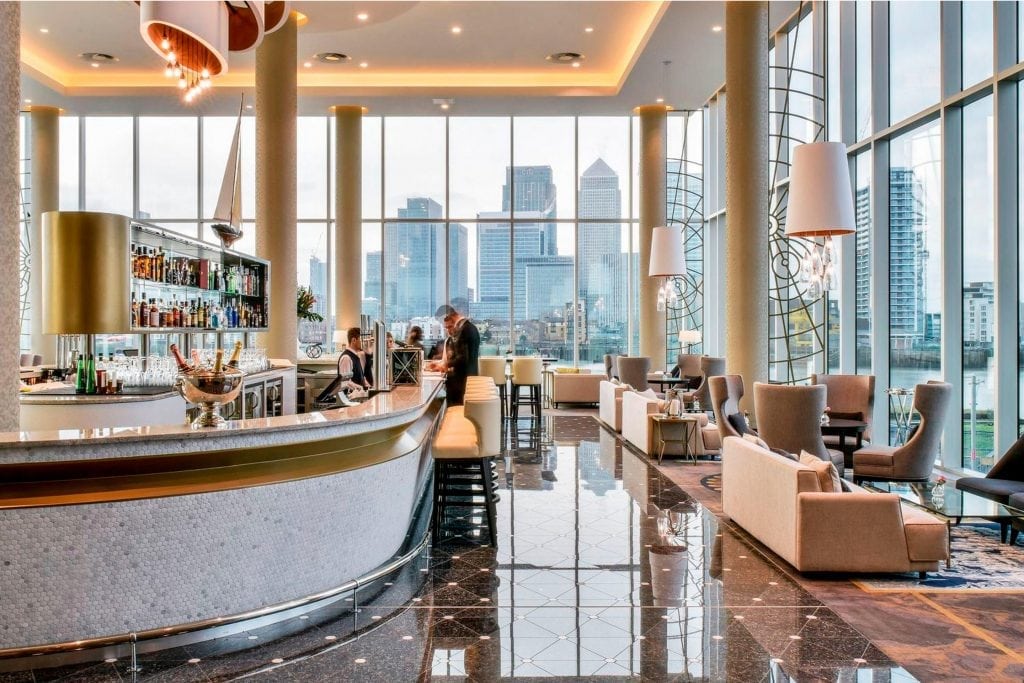 Top image is of the bar at the InterContinental London by the O2 arena. InterContinental Hotels Group has installed Amadeus's new hospitality tech platform at more than half of its properties. Inset photo: The lobby of The James New York-NoMad, part of Denihan Hospitality Group, which has contracted with Amadeus Hospitality to use its event software.