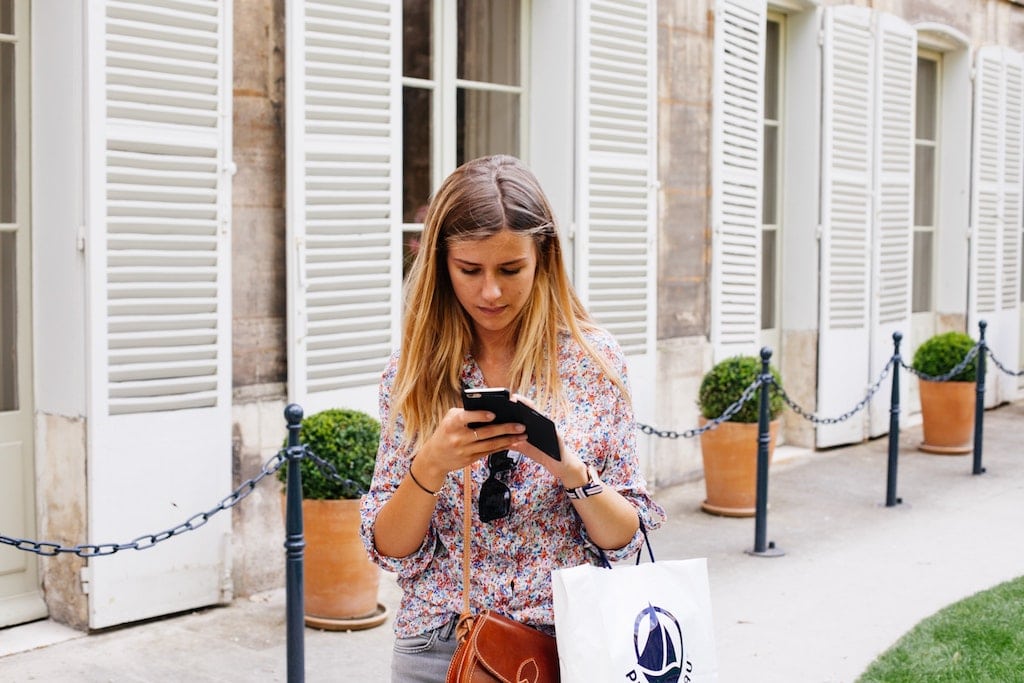Mobile has become an important factor to the in-destination experience. A woman uses her mobile phone while shopping.