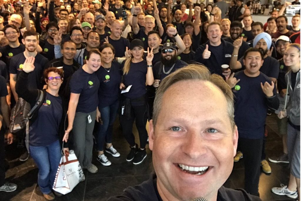 A September 2017 photo by Expedia Group CEO Mark Okerstrom at a charity event with some workers who support the travel company's more than 20 brands. Expedia reported its second quarter earnings on Thursday.