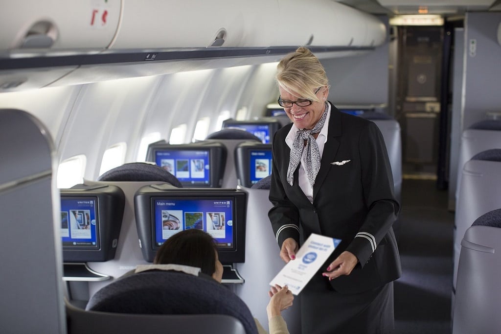 A United flight attendant in motion on a premium-service flight