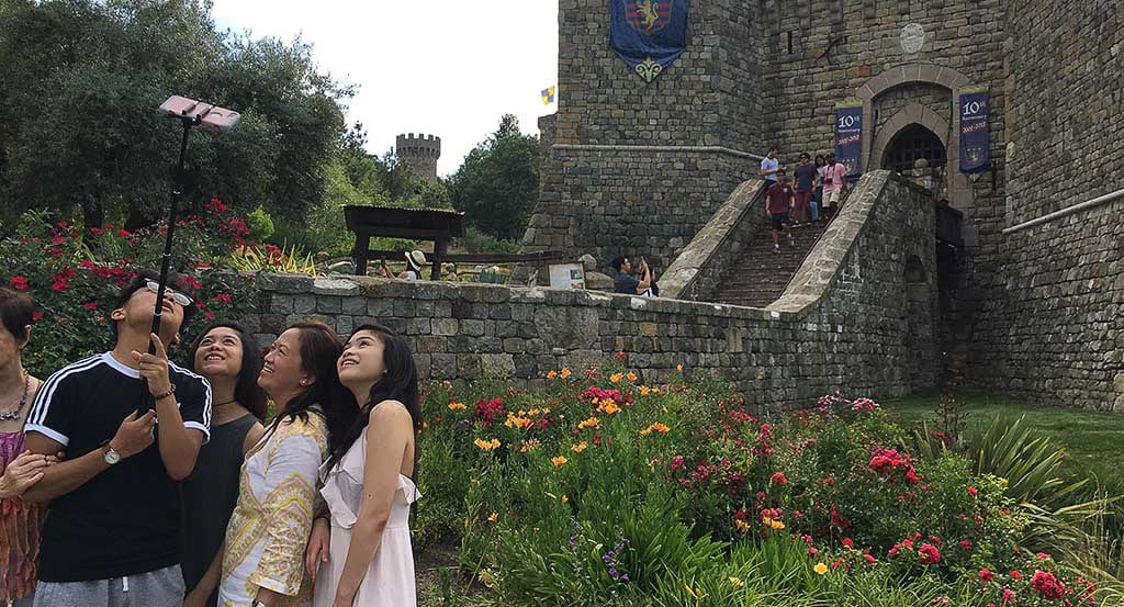 The global tours and activities sector is going through seismic shifts. Pictured are tourists using a selfie stick at Castello di Amorosa, an attraction in California's Napa Valley. 