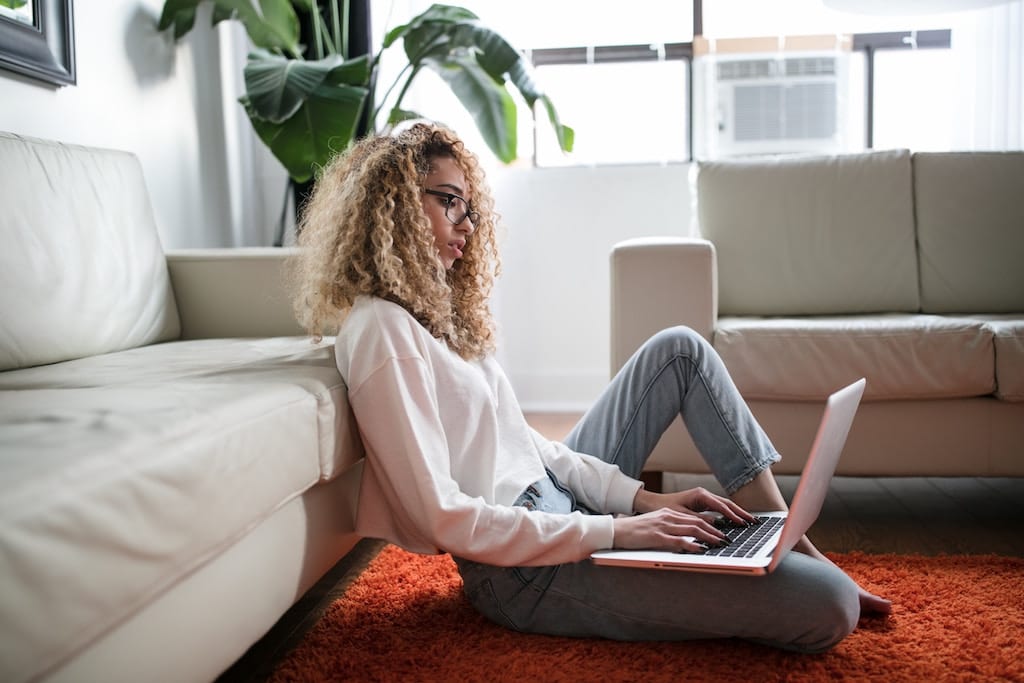 A woman is shown browsing her laptop. Wellness brands are grappling over Amazon partnerships that have the potential make their products accessible and bring scale, but can lead to weaker brand identity and valuation.
