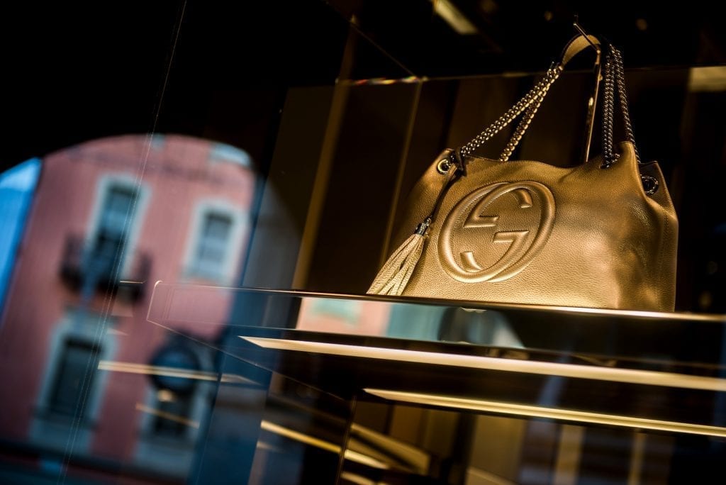 A gold leather handbag sits in the window display of a Gucci luxury goods store, in Lugano. Americans are getting sweet deals on luxury goods because of the strength of the dollar against the euro.