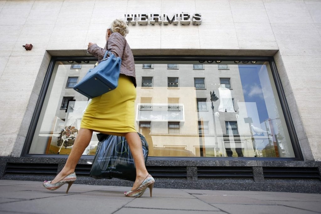 A pedestrian walks past a Hermes store in London. What can fashion retailers teach hospitality companies?