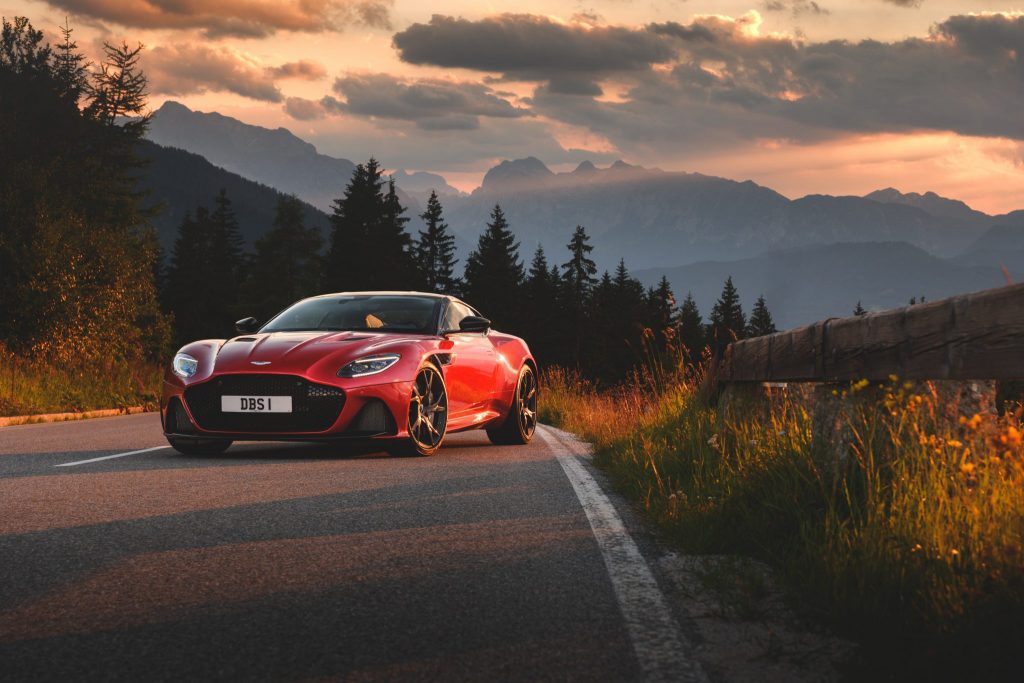 Aston Martin DBS Superleggera Hyper Red. Luxury car companies are teaming up with hotels.