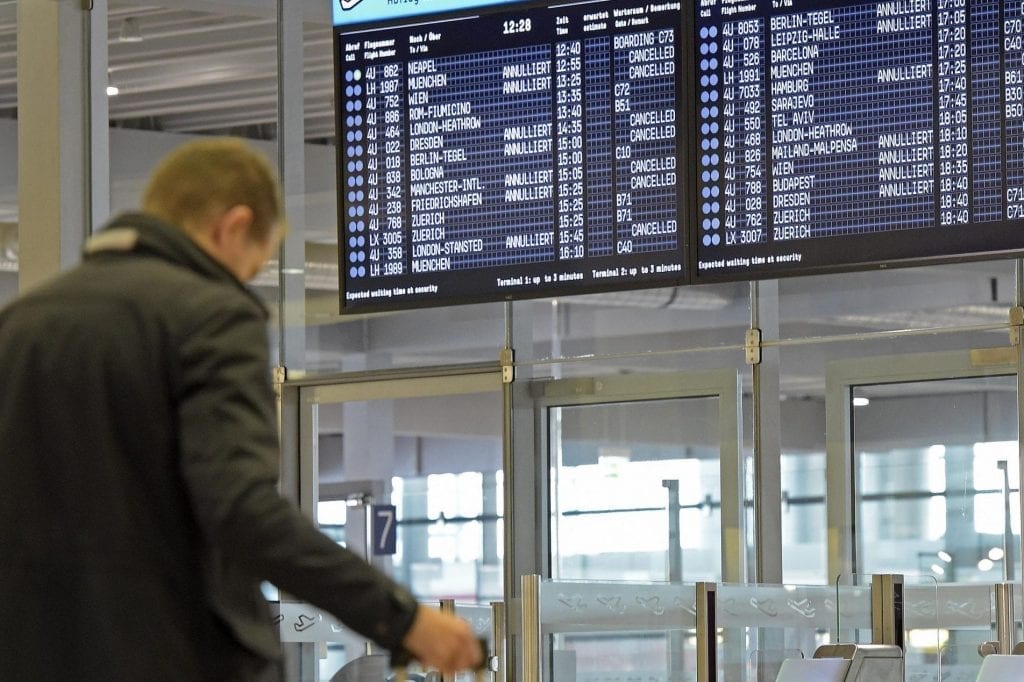 A traveler mulls his flight options at the airport in a 2015 photo. Many travelers these days are adding leisure trips to their business travels.