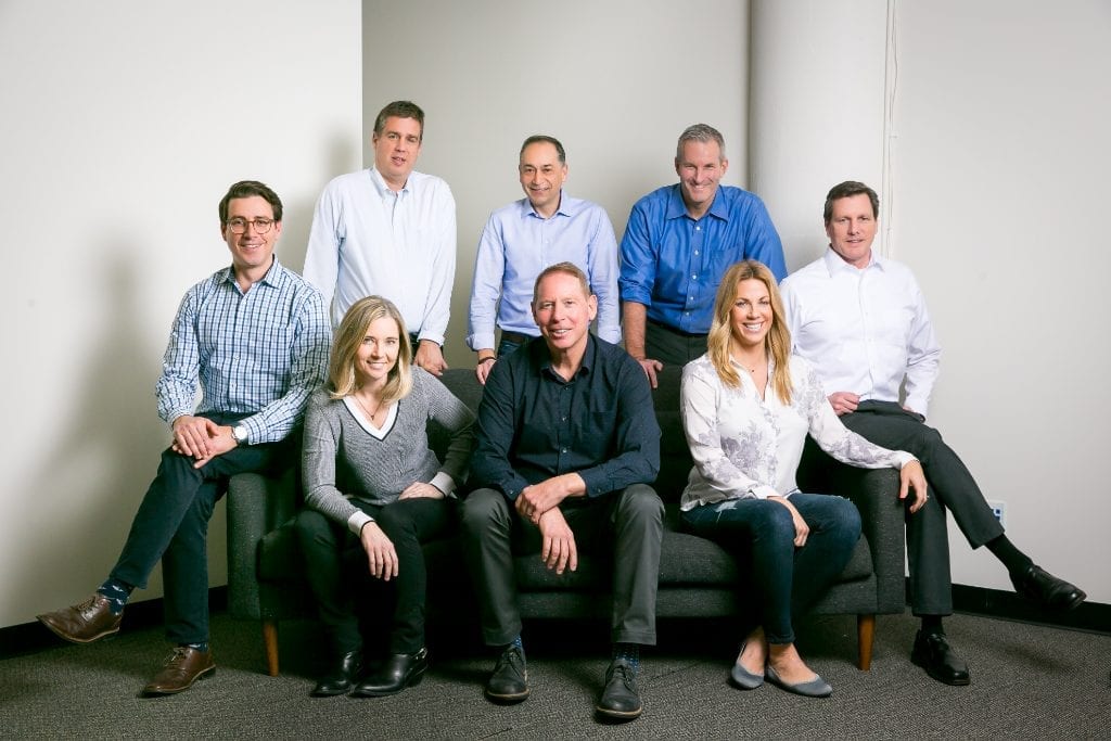 Switchfly, a travel tech firm specializing in loyalty and e-commerce upselling has been taken over by private equity firms Golub Capital and L Capital. Shown here is the executive team. Front and center, seated, is new CEO Craig D. Brennan.