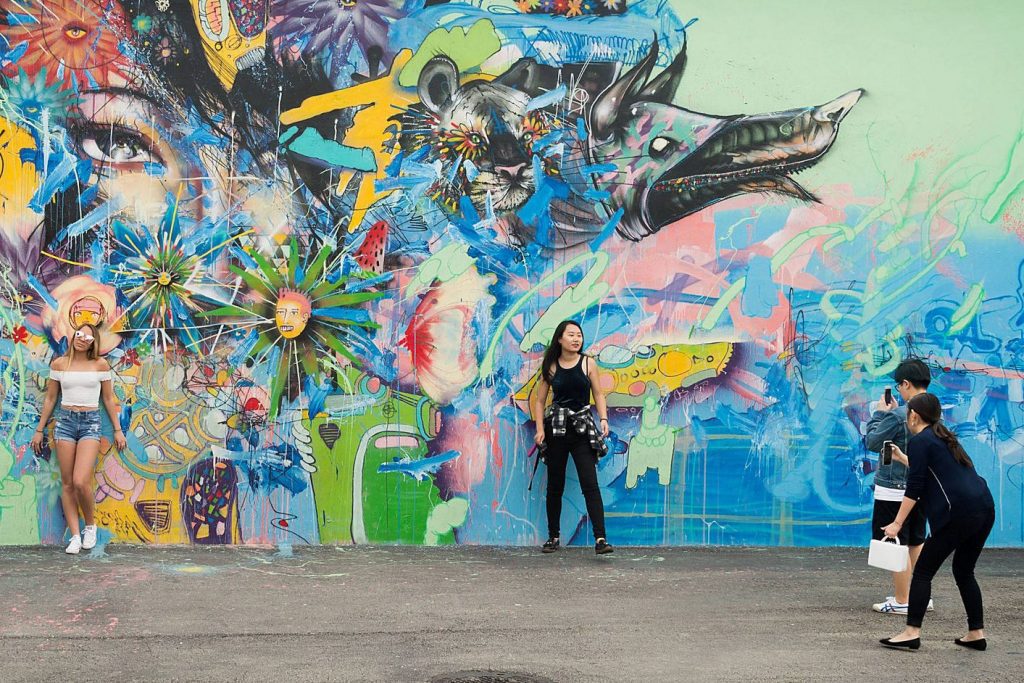 Tourists at a mural in the Winwood section of Miami. Asian and Hispanic travelers are potentially a huge market for travel sellers.