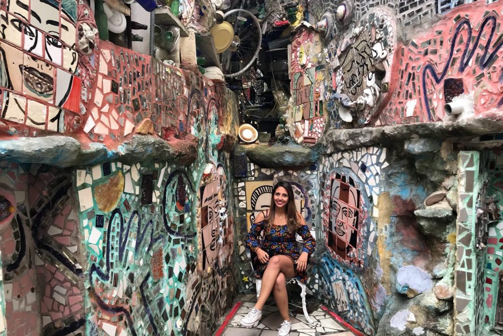Milena Rocha Vitor went on a mystery trip to Philadelphia planned by a travel agency, Pack Up + Go. She's pictured with a Isaiah Zagar mosaic in the background at Philadelphia's Magic Gardens.