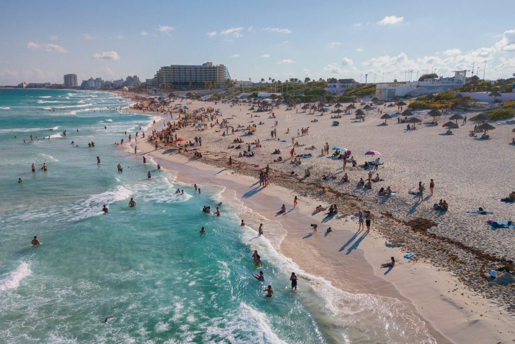 Visitors are shown on the beach in Cancún, Mexico. The country has disbanded its tourism board and announced a slew of new strategies for bringing visitors to the country.
