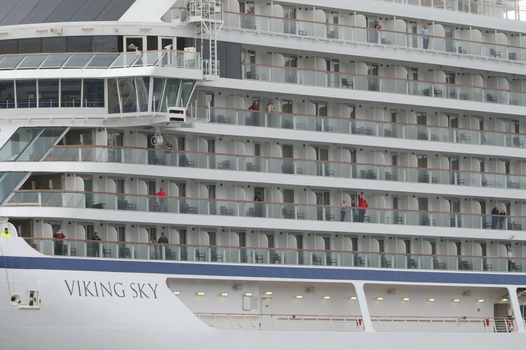 Some of the remaining passengers look out as the cruise ship Viking Sky arrives at port off Molde, Norway, Sunday March 24, 2019, after having problems and issuing a Mayday call on Saturday in heavy seas off Norway's western coast. Rescue helicopters took more than 475 passengers from a cruise ship that got stranded off Norway's western coast in bad weather before the vessel departed for a nearby port under escort and with nearly 900 people still on board, the ship's owner said Sunday. 