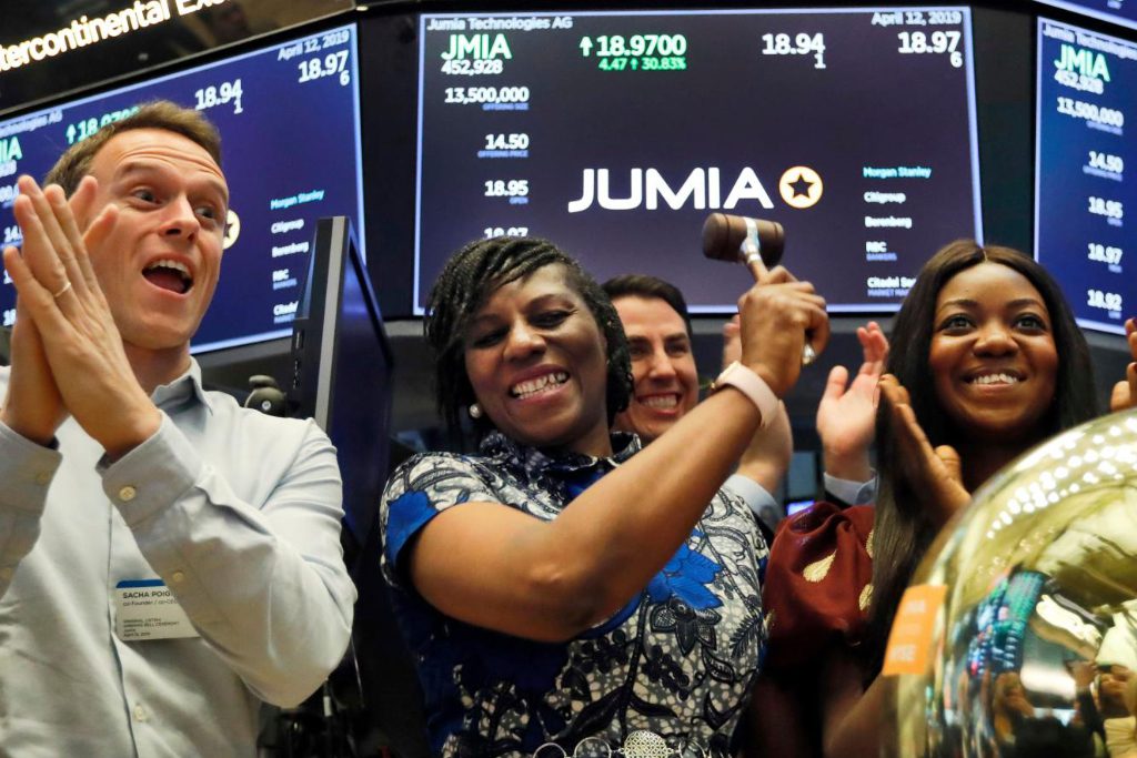 Jumia co-CEO Sacha Poignonnec, left, applauds as Jumia Nigeria CEO Juliet Anammah, center, rings a ceremonial bell when the company’s stock begins trading, on the floor of the New York Stock Exchange, Friday, April 12, 2019. Jumia has a travel unit that faces competition with regional and global rivals.