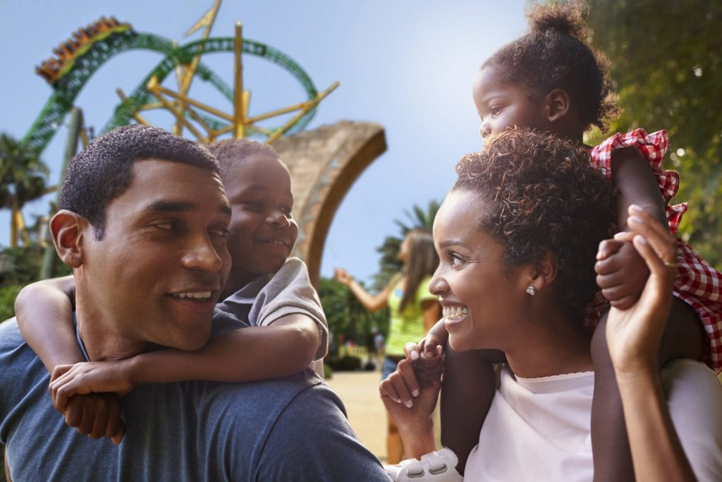 African American parents giving children piggyback rides at Busch Gardens in Tampa, Florida