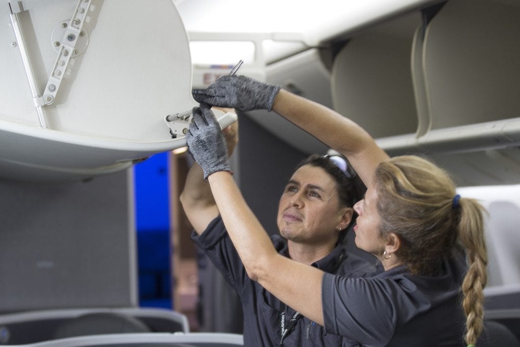 American Airlines maintenance technicians repair an overhead bin. The airline is in a labor dispute with its mechanics union.