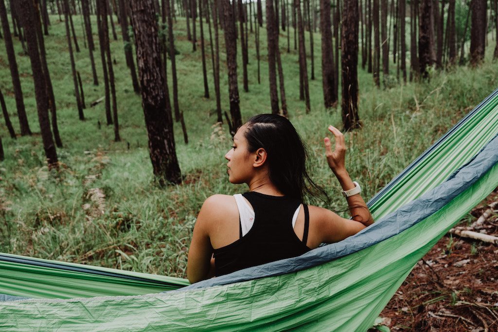 A woman is shown in nature. More affluent travelers are looking to spend their cash on trips centered around their physical and mental well-being.