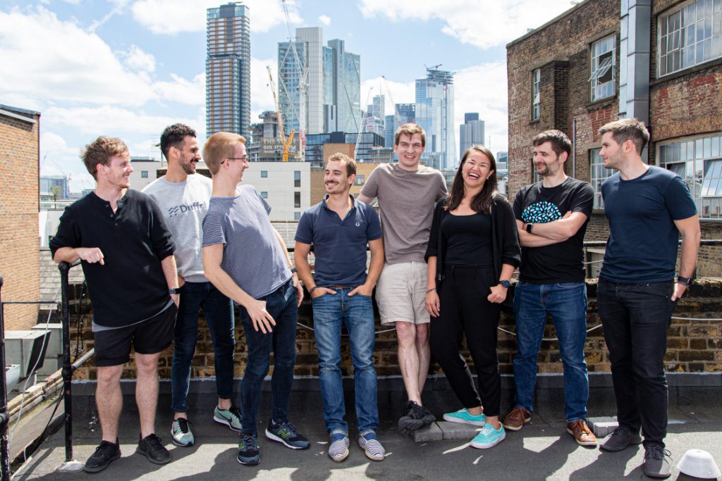 A photo of key team members for Duffel, a travel startup that has been backed by Benchmark, a famous investment firm. Steve Domin, co-founder and CEO of Duffel, is in the center wearing shorts.