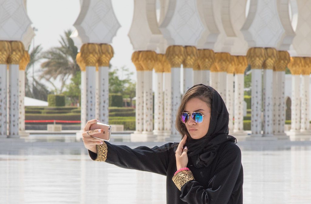 A tourist taking a selfie near a mosque in Abu Dhabi. The online travel market is projected to reach $15 billion by 2023 across the Middle East region.