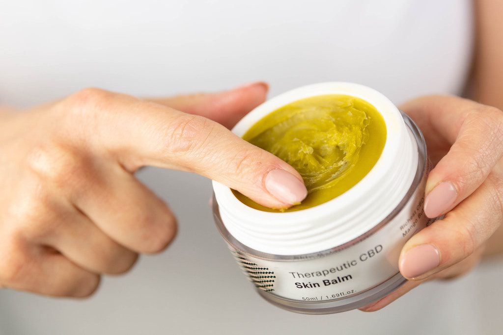 A CBD-based salve is shown. Companies that primarily sell items like apparel and shoes want in on CBD beauty.