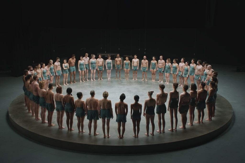 A screenshot from Momondo's The World Piece video in which some 60 participants create an interwoven tattoo. 