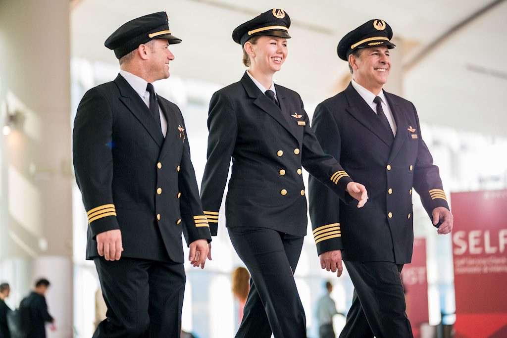 Three Delta Air Lines pilots walk through an airport. The carrier's pilot union is concerned about the airline's joint ventures.