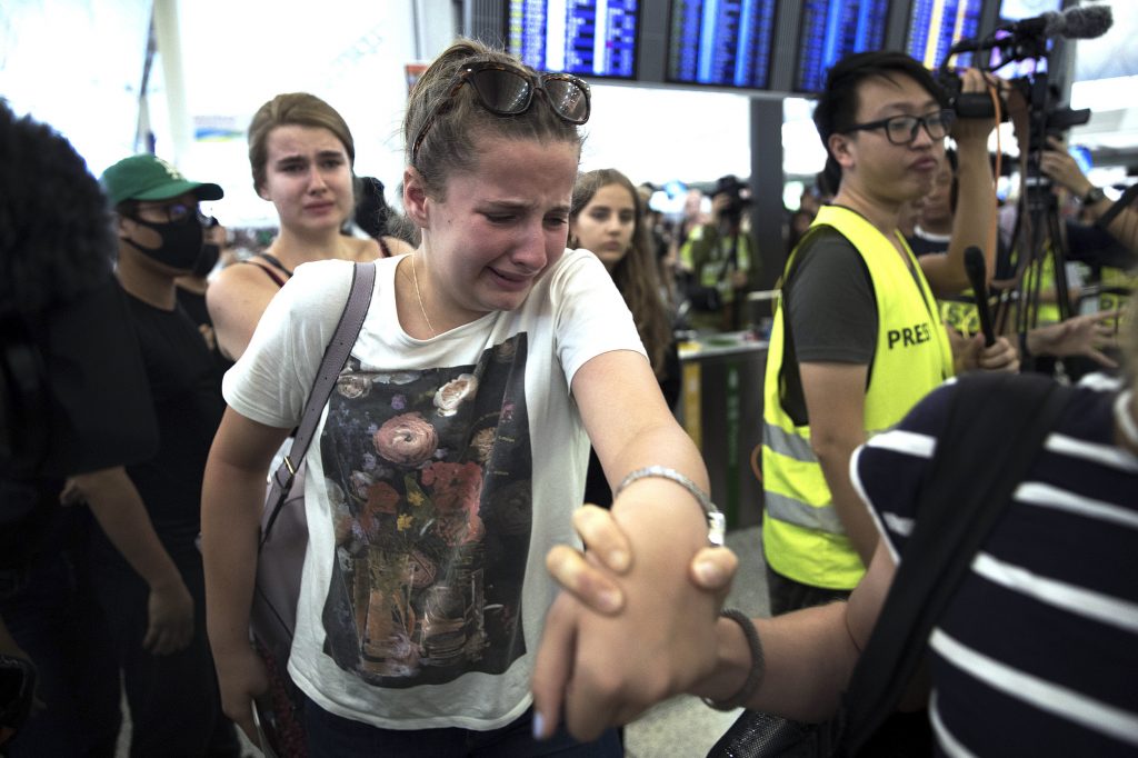 Travelers walk through Hong Kong's airport Tuesday before it was closed, again. Protestors have been clashing with police. 