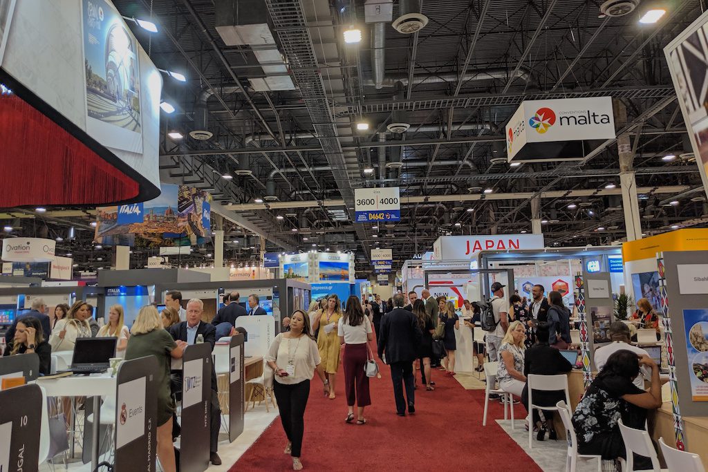Attendees walk between booths at IMEX America 2019 at the Sands Expo in Las Vegas. 